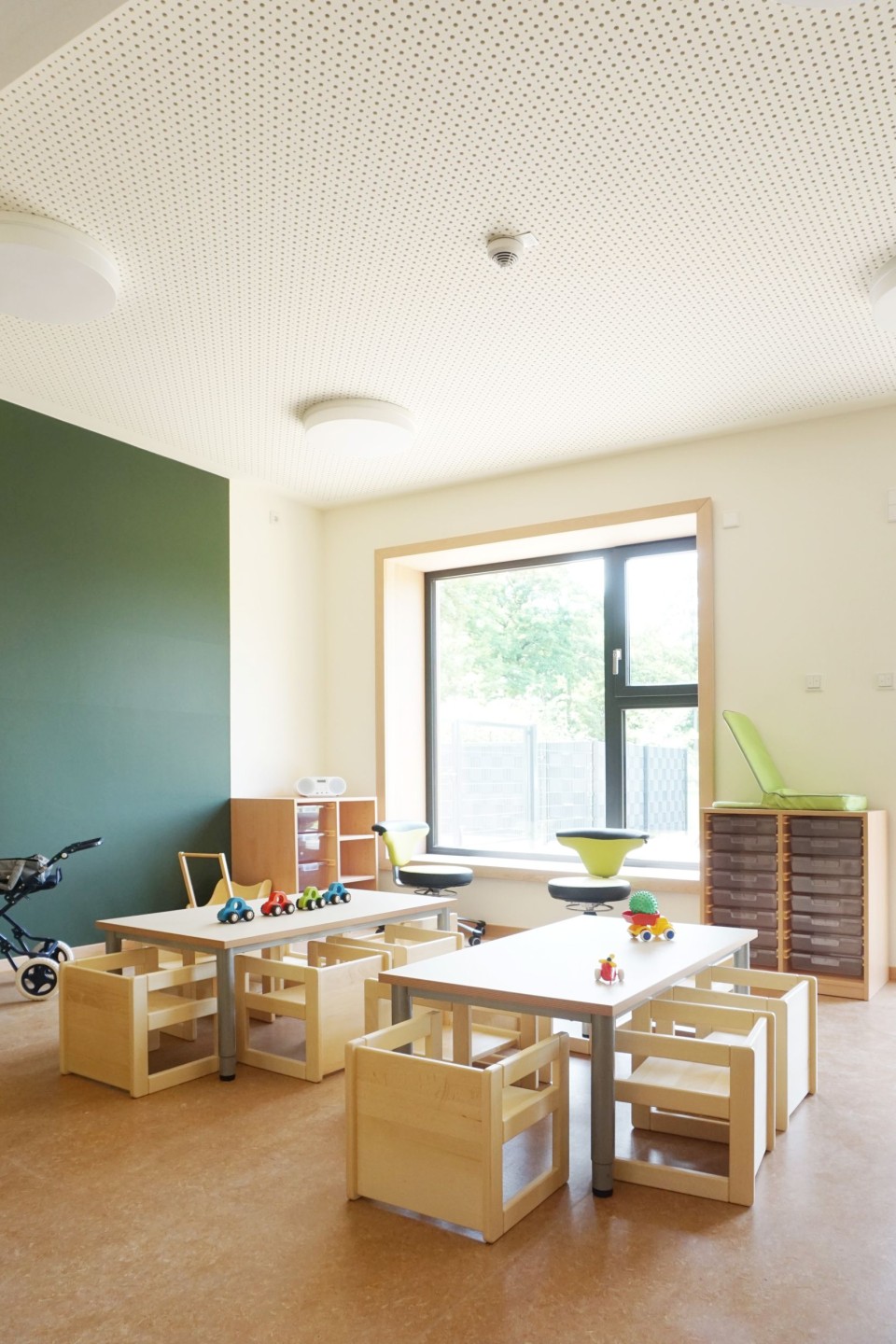 Freundlich eingerichtete Gruppenräume mit Holzmöbeln und viel Platz zum Spielen