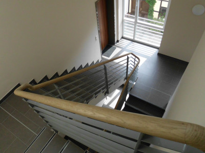 Im Treppenhaus Geländer mit Holzlauf