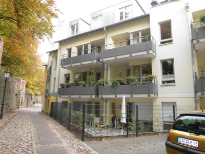 Rückansicht mit Stadtmauer, ein schmaler Weg trennt das Gebäude von der Stadtmauer